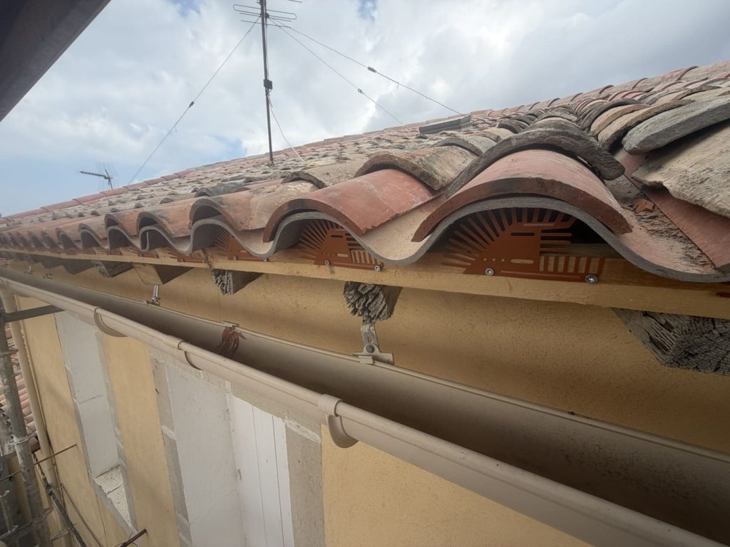 Bas de toiture rénové plaques fibrociment, tuiles canal, closoirs ventilés et gouttière neuve