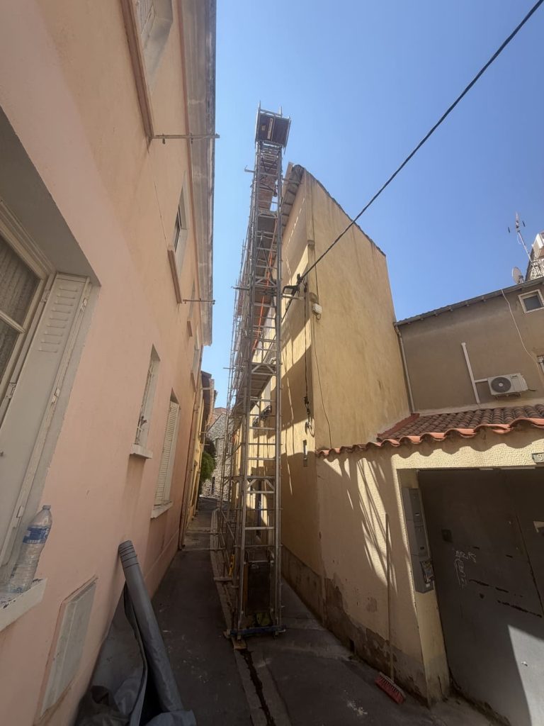 Monte-charge installé dans une ruelle étroite de Frontignan pour acheminer les matériaux sur la toiture